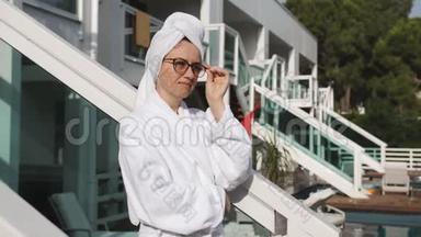 穿浴袍的女人站在阳台上的豪华别墅